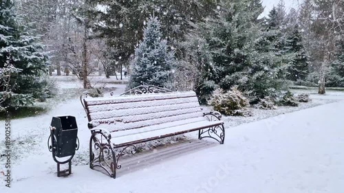 Wallpaper Mural A snow-covered park bench surrounded by evergreen trees in a winter landscape. Snow blankets the ground, creating a serene atmosphere. Torontodigital.ca