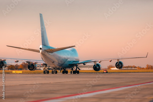 Large cargo airplane taxiing on airport runway for take off in warm afternoon light. Air freight, logistics, and global transportation concept. © Chalabala