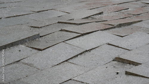 Uneven and loose pavement tiles on city street