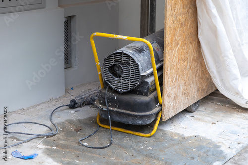 Photos Powerful industrial space heater with a yellow frame, actively drying a concrete