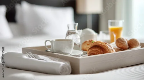 Fototapeta Breakfast Tray Placed on a Bed in a Hotel Room Showing Simple Food Items and Drinks for a Morning Meal