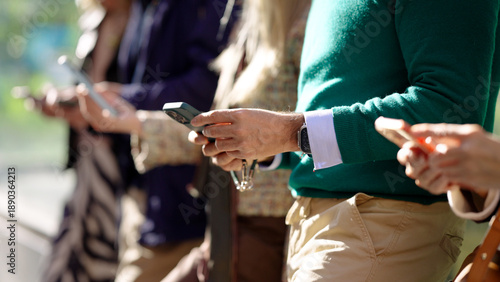 Tableau sur toile People in a row holding and operating mobile devices, illustrating reliance on d