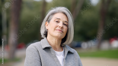 Billede på lærred Confident mature woman with grey hair smiling, enjoying an outdoor moment