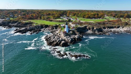 Aerial view of Portland Head Light with its white tower standing tall against the rugged coastline and deep blue sea, Cape Elizabeth, Maine, United States.