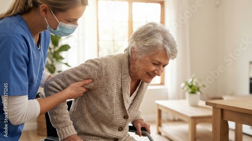 Elderly woman receiving assistance from caregiver helping mobility indoors