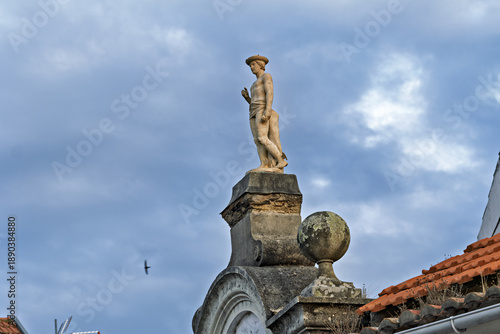 Quadro em tela Statue atop an ornate architectural structure in Ovar, depicting a classical male figure in contrapposto stance holding an object