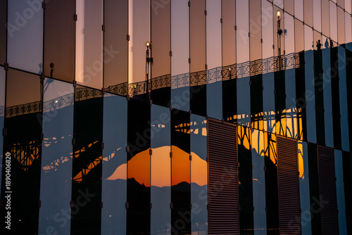 Abstract reflection of the historic Old Bridge in the modern glass facade of the Faculty of Medicine in Maribor, Slovenia at sunset