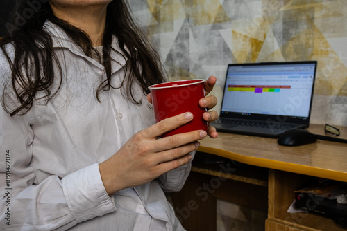 Casual work-from-home setup with a person enjoying a coffee break