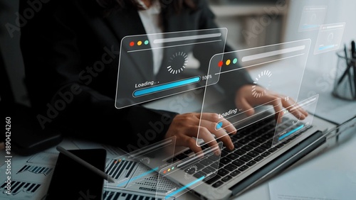 Obraz na plátně Business professional working on a laptop with digital interface displaying loading progress and analytical data in a modern office setting Gluon