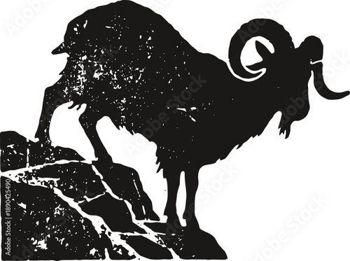 Mountain goat standing on rocky cliff silhouette with curved horns and rugged terrain