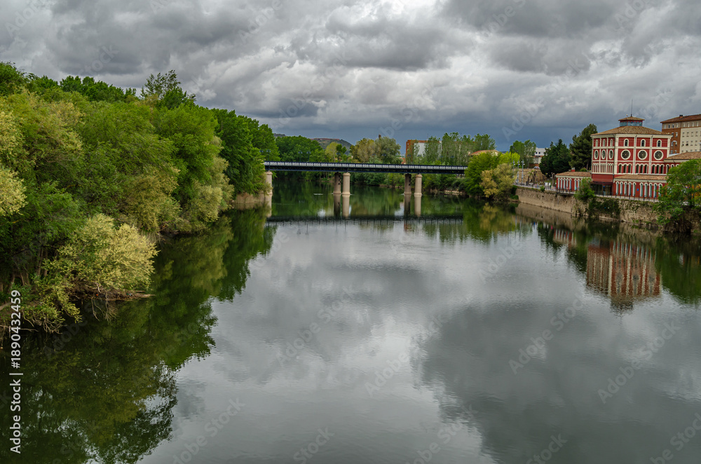 Fototapeta premium Ebro River cityscape in Logrono, Spain, under cloudy daytime sky