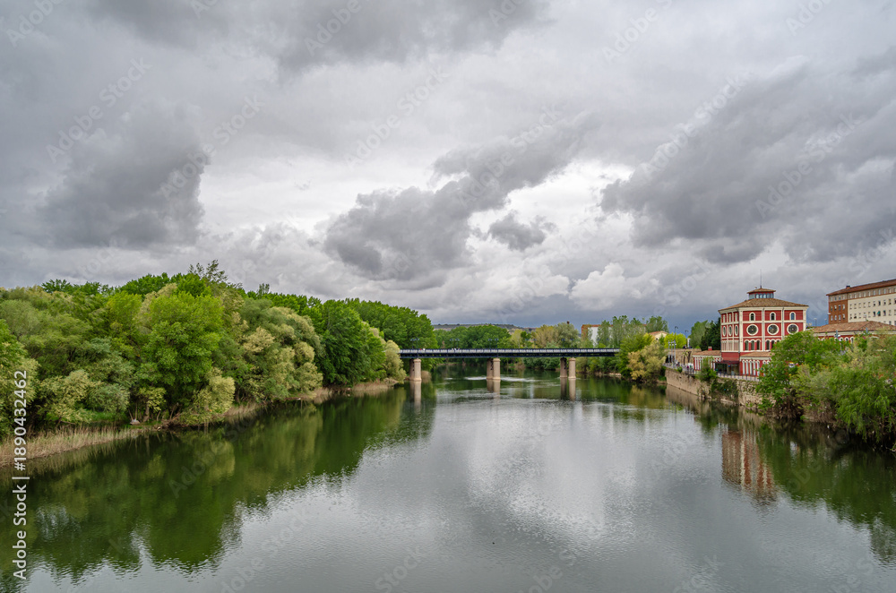 Fototapeta premium Ebro River cityscape in Logrono, Spain, under cloudy daytime sky
