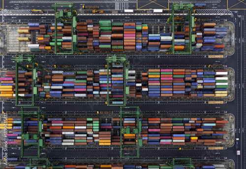 Aerial view of a vibrant tapestry of shipping containers stacked in neat rows, creating a geometric mosaic of colors and textures at the harbor, Singapore, Singapore.