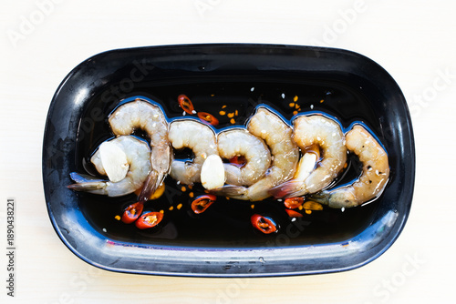 Korean-style pickled shrimp in savory soy sauce with garlic and chili, served with steamed rice, dried nori, and spicy dipping sauce. Top view close-up.