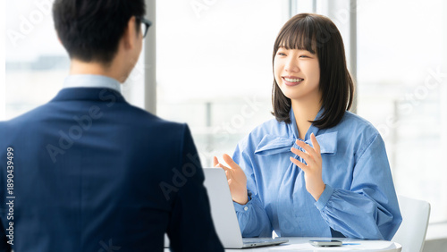 Foto ノートパソコンを使いながら対面で会話をする日本人女性・ビジネスウーマン, A Japanese woman talking face to face while