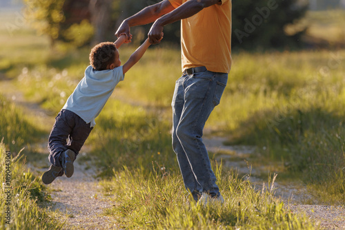Canvas Print Father lifts child in playful spinning moment outdoors