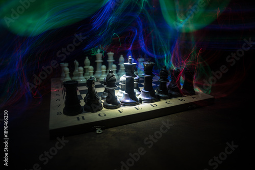 Chess board game concept of business ideas and competition. Chess figures on a dark background with smoke and fog.