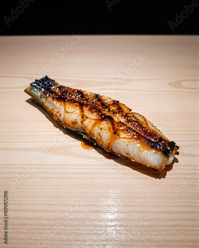 Grilled Eel Sushi with Teriyaki Sauce Presented on a Polished Wooden Table