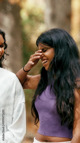 Two young Indian female friends laughing and enjoying a walk together. Beautiful best friends sharing a joyful moment and bonding outdoors