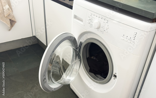 open door washing machine on a white and wood background