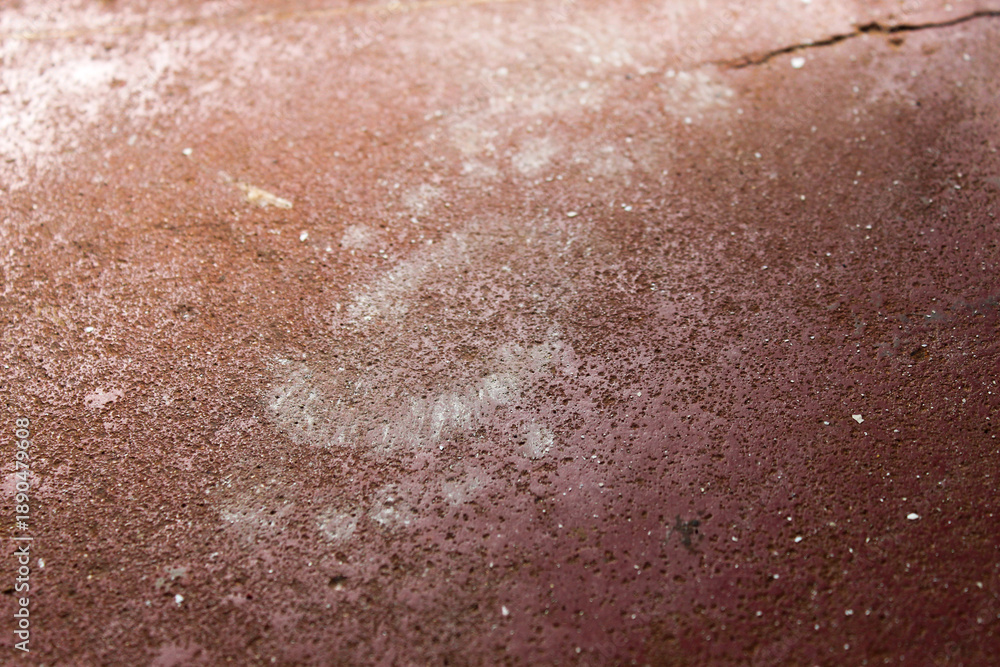 Fototapeta premium Close up of white footprints on a red floor. A child's footprints.