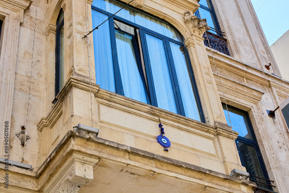 Naklejka premium Ornate stone building with blue windows and evil eye charm