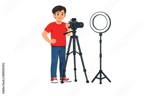 Young man stands next to a camera on a tripod and a ring light in a studio setting while preparing for a photoshoot in the afternoon