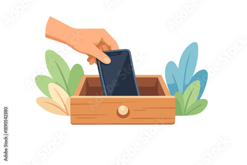 Hand places smartphone into a wooden drawer surrounded by green leaves during a quiet moment in a workspace