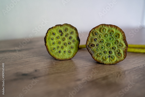 Close-up of dried lotus seed pods on a wooden surface. Natural botanical texture with organic shapes and earthy tones, minimal composition with copy space