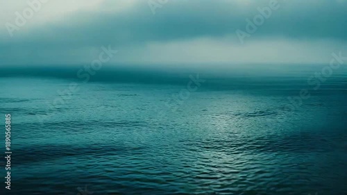 Foggy ocean water meeting a misty sky creates a serene and mysterious natural landscape, illustrating themes of tranquility, vastness, and atmospheric conditions
