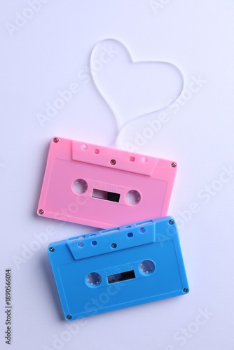 Music cassettes and heart made with tape on white background, top view