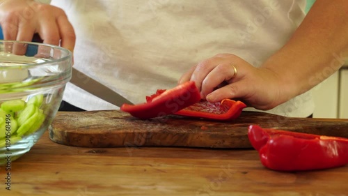 Woman cutting red pepper for salad
