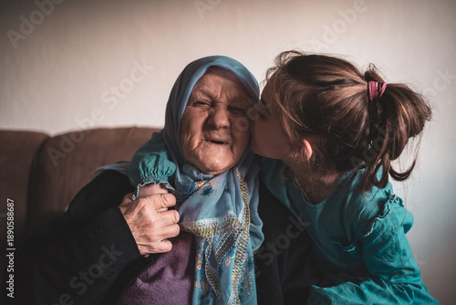 Fotografie A smiling Muslim grandmother and grandchild spend a lovely time together, they are happy and enjoy themselves