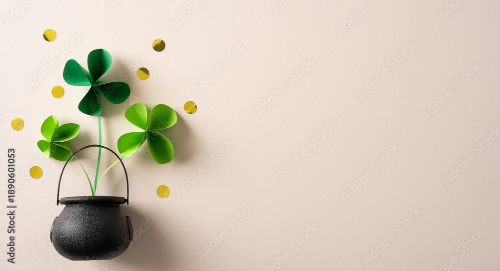 Naklejka premium Vibrant green shamrocks rise from a small black cauldron, accented by gold coins. This festive image evokes luck, tradition, and holiday spirit, ideal for St. Patrick's Day cards promotions