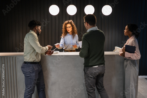 Photography People interacting with a smiling woman at reception desk