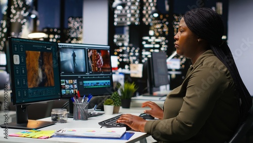 Fotografie Woman video creator working on editing a movie montage project, multitasking with dual monitors
