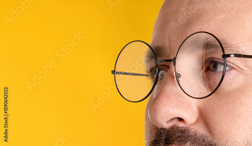 Photos Man in glasses on orange background, closeup. Space for text