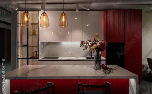 Fotografia Luxury kitchen island with marble worktop and red cabinetry