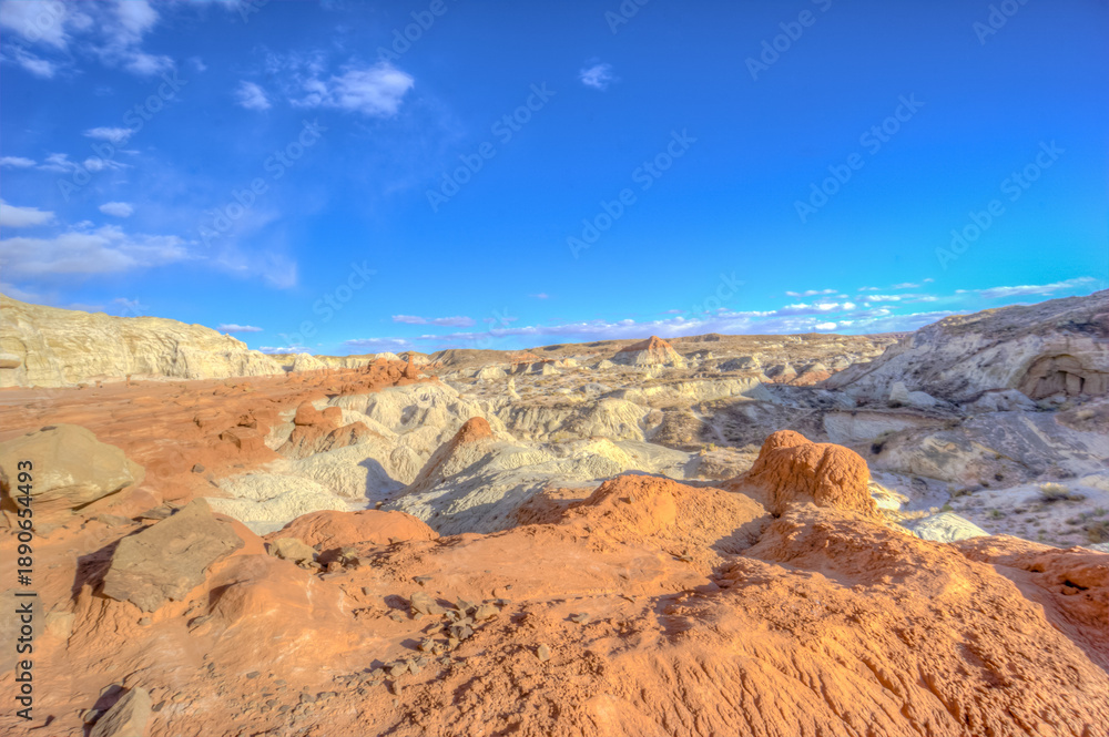 Fototapeta premium A desert landscape with a blue sky and a few clouds