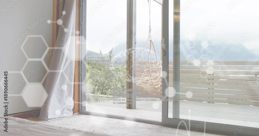 Obraz premium Framing sliding glass door revealing deck with woven chair at home, showing sheer curtain overlays