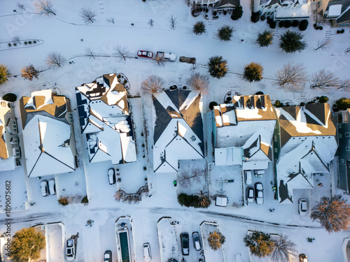 Bilde på lerret Drone aerial view of residential suburb with single-family homes covered in fresh snow on roofs, yards and streets under clear winter sky