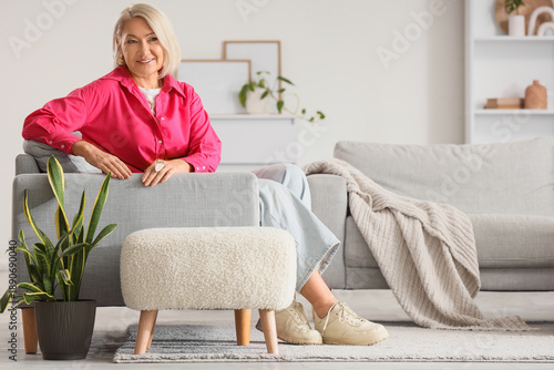 Mature woman sitting on gre...