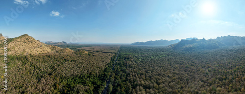 Wallpaper Mural Aerial panorama vast forest with rugged mountain peaks under clear blue sky rich diversity of tree colors and textures highlights the natural beauty and ecological variety of the landscape. Torontodigital.ca