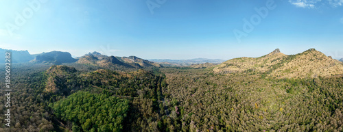 Wallpaper Mural Aerial panorama vast forest with rugged mountain peaks under clear blue sky rich diversity of tree colors and textures highlights the natural beauty and ecological variety of the landscape. Torontodigital.ca