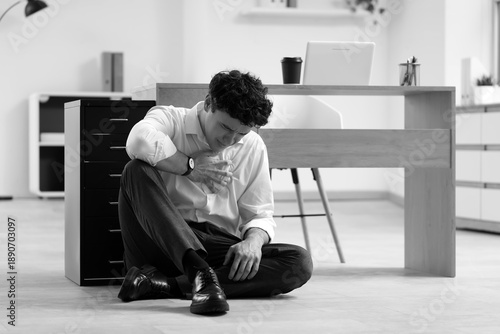 Quadro em tela Young businessman having panic attack near desk in office