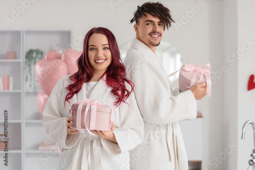 Young lovely couple with gifts in bathroom. Valentine's Day celebration