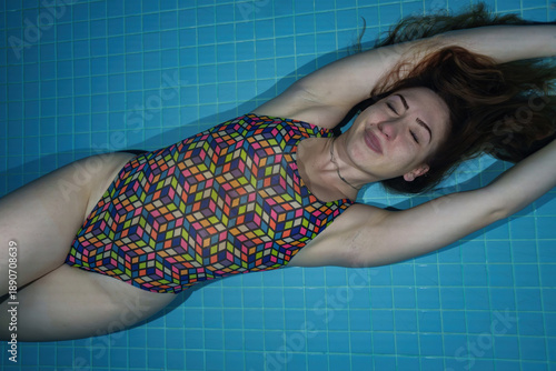 A female swimmer poses underwater in the pool.