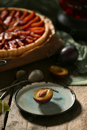 Board with tasty plum pie a...