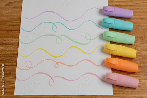 Pastel Highlighters Next to Colorful Wavy Line Drawing on Paper