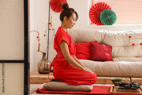 Young Asian woman with tea ...